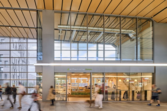 Architekturfoto beleuchtetes Bahnhofscafé mit Passanten