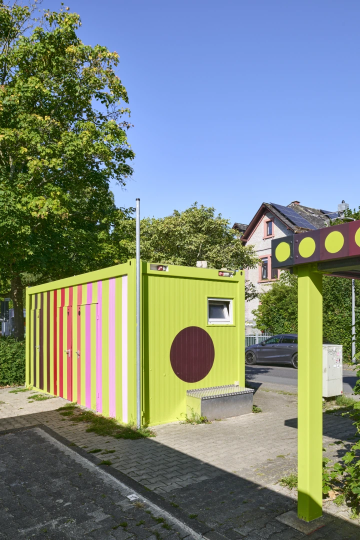 Lackierter Toilettencontainer mit Fahrradunterstand im Anschnitt