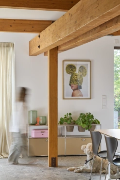 Detail Wohnraum mit sichtbaren Holzbalken, Kunstwerk und Designer Mobiliar